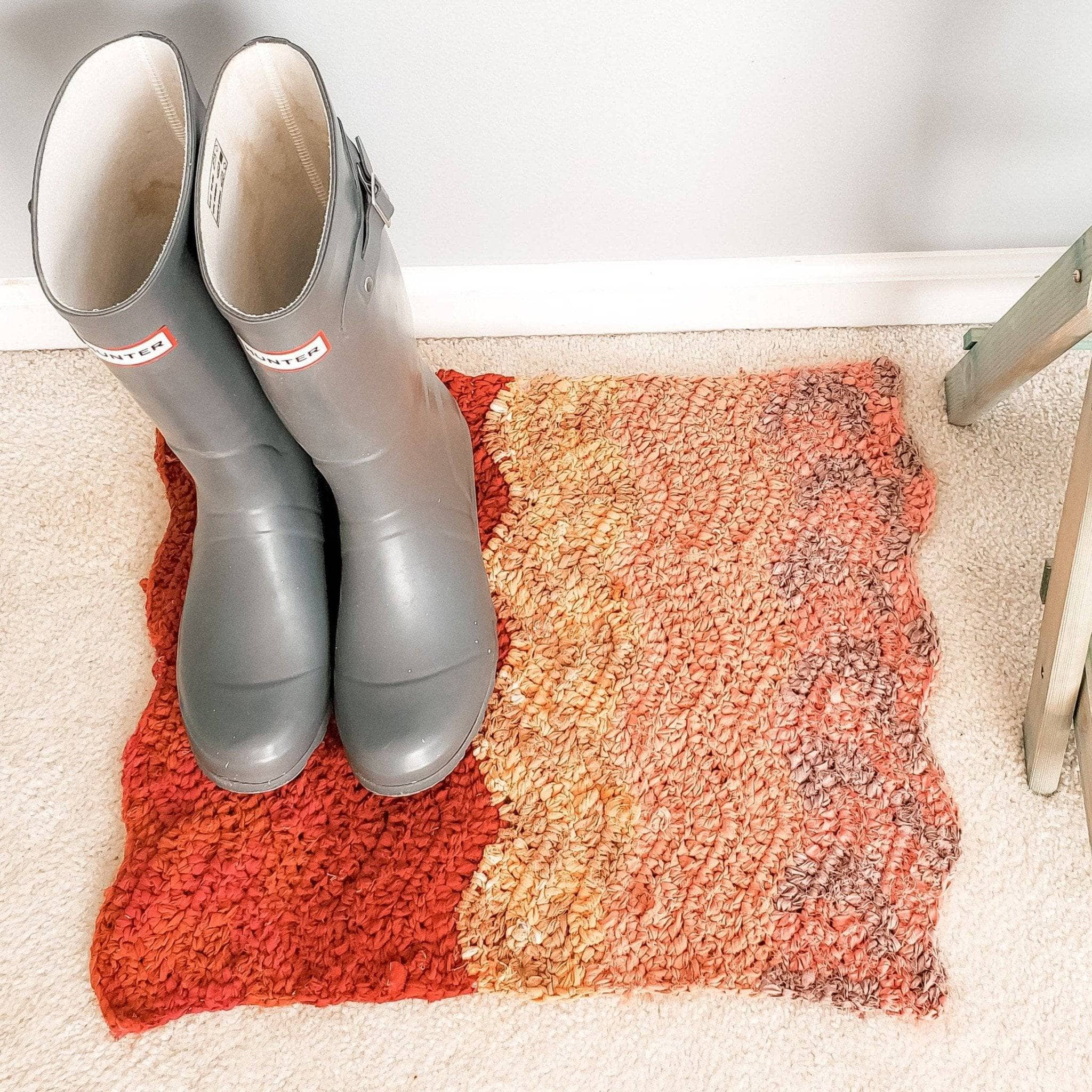Finished crochet rug featuring a natural wave stitch pattern lying on a wooden floor.