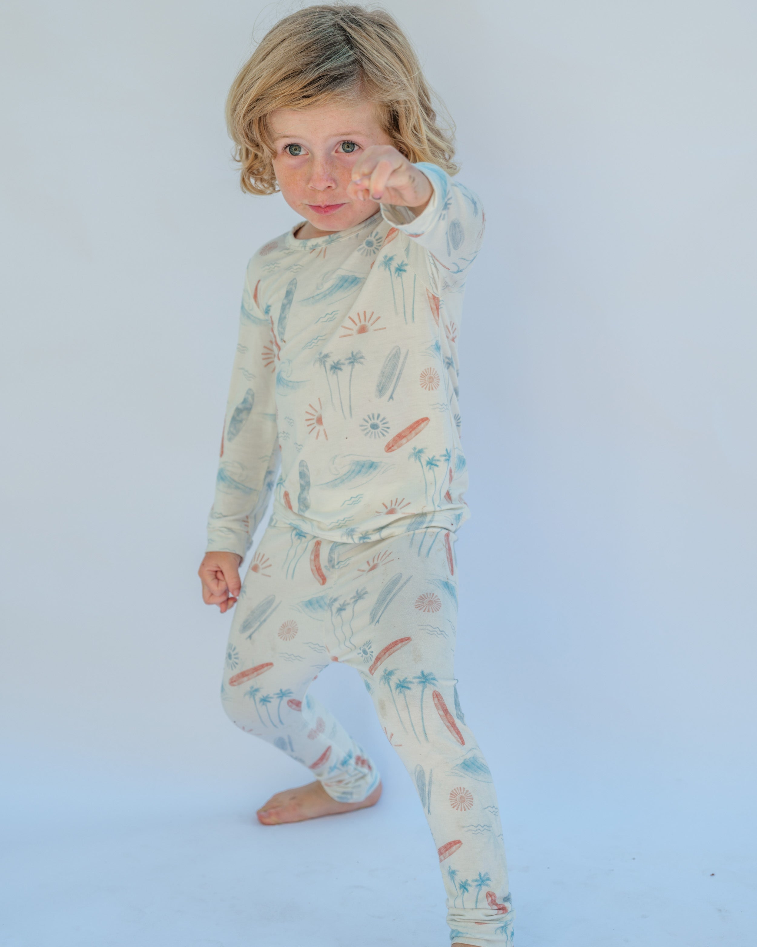 Child wearing a patterned pajama set on a white background