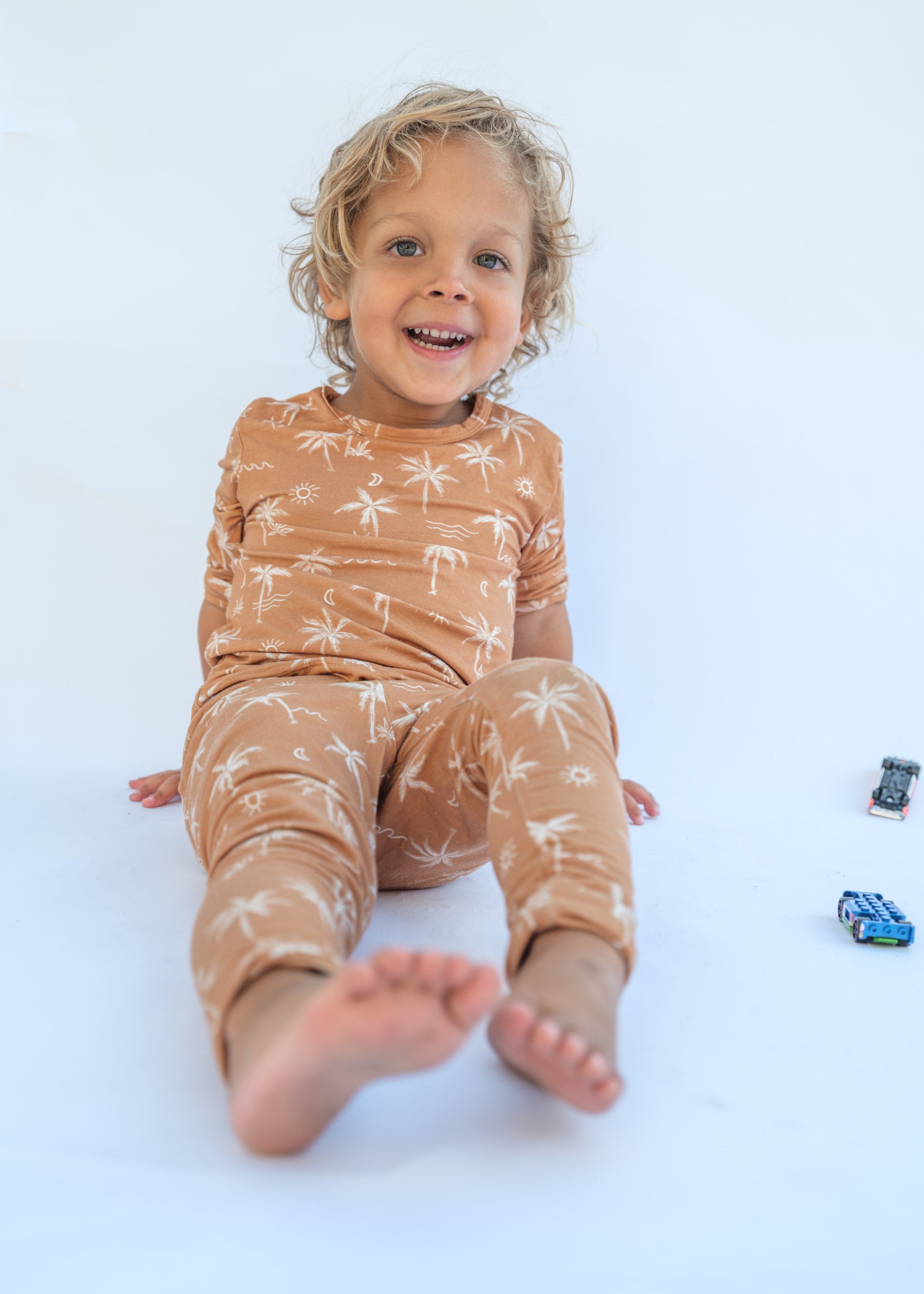 Child wearing a brown outfit with white patterns on a white background
