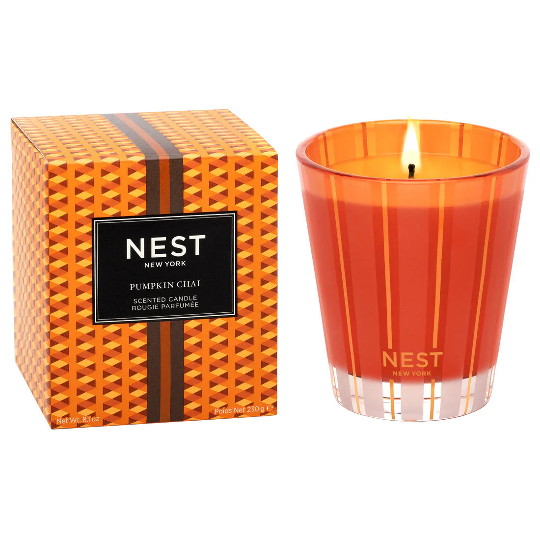 Pumpkin Chai scented candle in a glass vessel on a wooden surface with fall decor