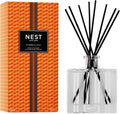 Nest New York Pumpkin Chai Reed Diffuser in a vibrant orange geometric glass bottle with black reeds.