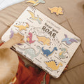 Minimalist wooden dinosaur puzzle with colorful prehistoric creatures on a neutral wooden board in a modern nursery setting.
