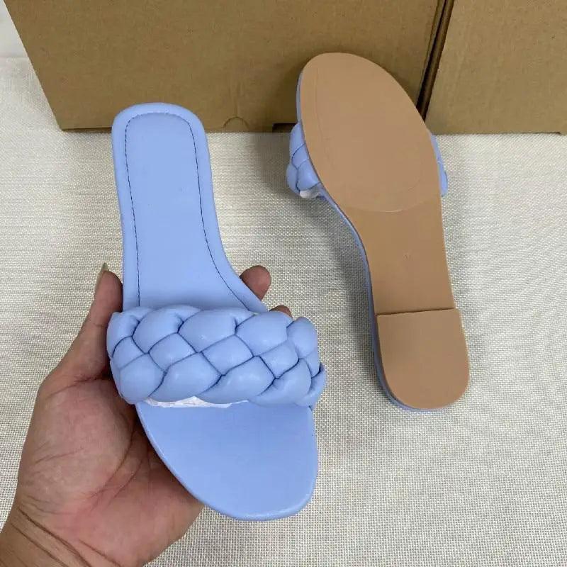 Designer-inspired women's flat leather slides available in blue, black, white, and pink.
