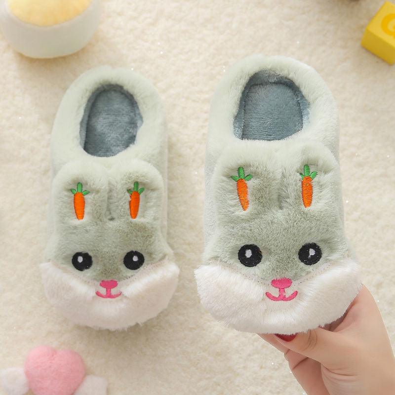 A pair of soft, fuzzy children's unicorn knit slippers in pastel colors, featuring a slip-on design with a memory foam sole.