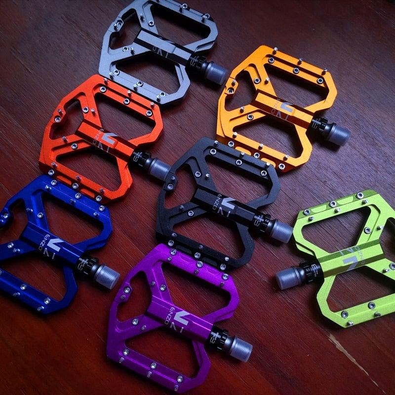 Set of colorful alloy mountain bike flat pedals with non-slip platform and 9/16 inch spindle