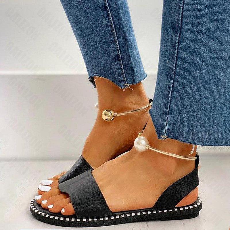 Women's flat slingback sandals with pearl embellishments on a light background