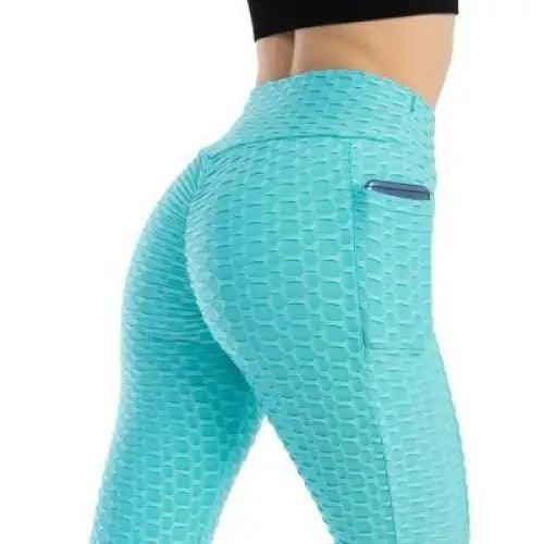 Woman wearing high-waist fitness leggings with side pockets in teal, black, and pink colors