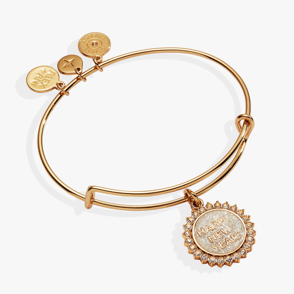 Gold expandable wire bangle with a white glitter Happy New Year charm and crystal accents.