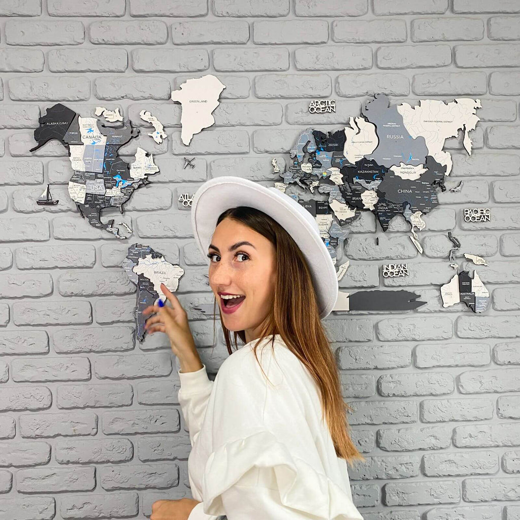 Modern 3D Wooden World Map in Nordik colors (black, grey, white) mounted on a minimalist living room wall.