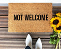 Minimalist Not Welcome doormat in brown natural coir with black typography