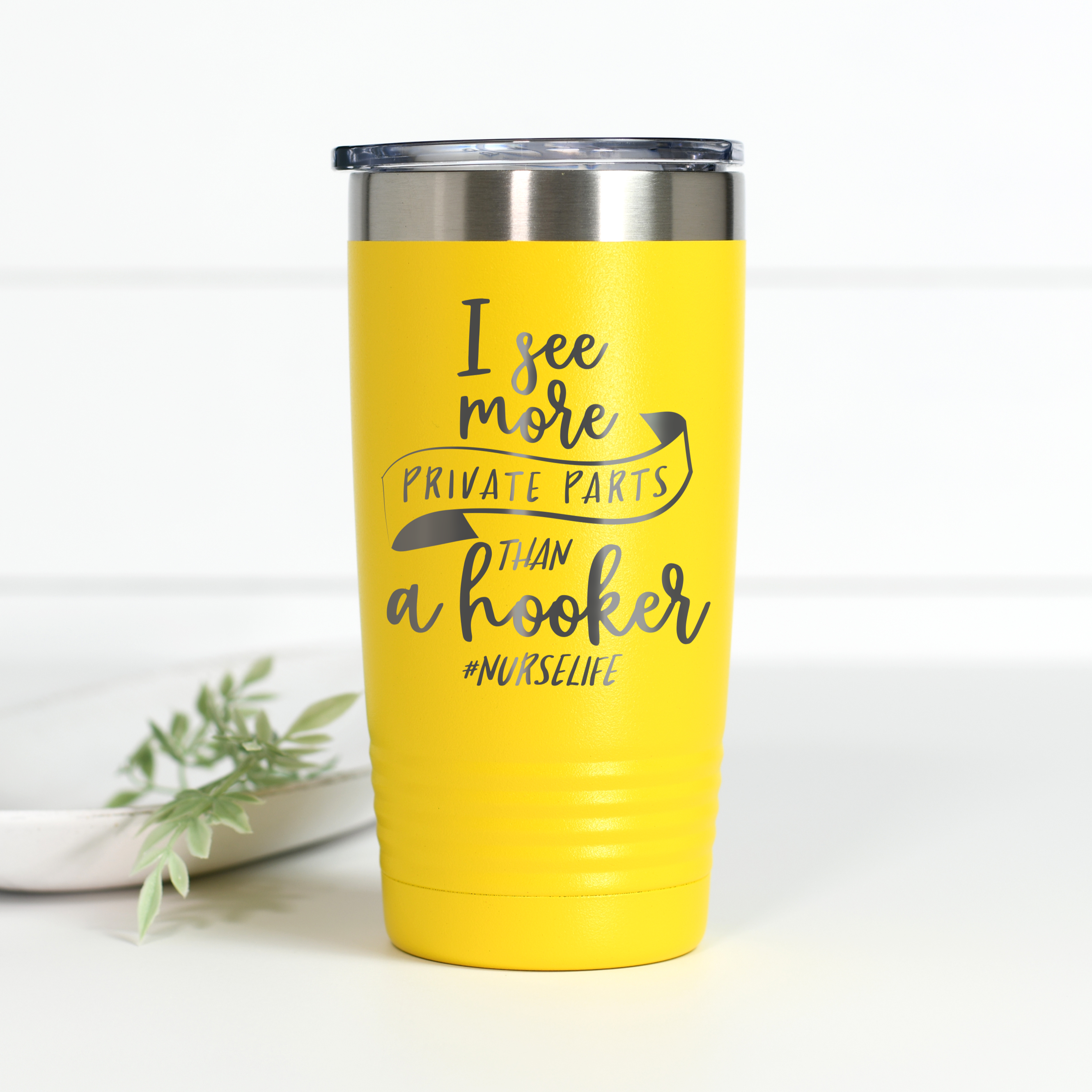Bright yellow 20 oz stainless steel tumbler with the text 'I see more private parts than a hooker #NurseLife' laser engraved on the front.