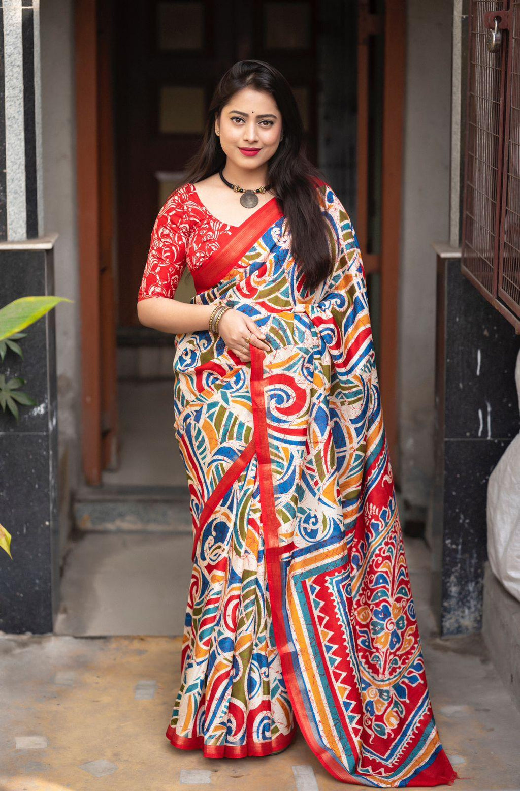 Red cotton crepe saree with multi-color traditional batik print design.