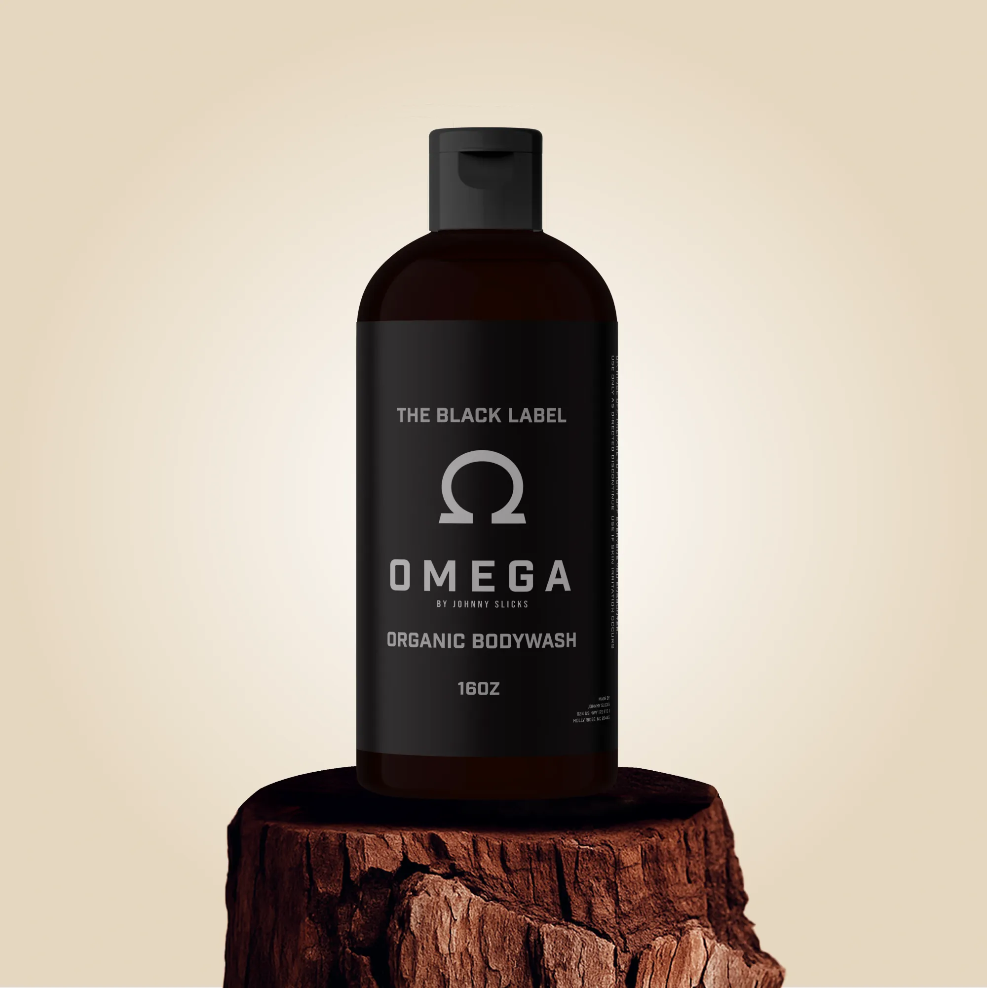 A 16oz bottle of Omega Organic Body Wash by Johnny Slicks standing on a wooden stump.