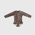 Girl wearing a long sleeve leopard print one-piece swimsuit with ruffle leg details and a front zipper at the beach.