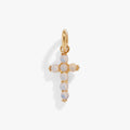 Close up of an iridescent opal cross charm in gold and silver stainless steel.