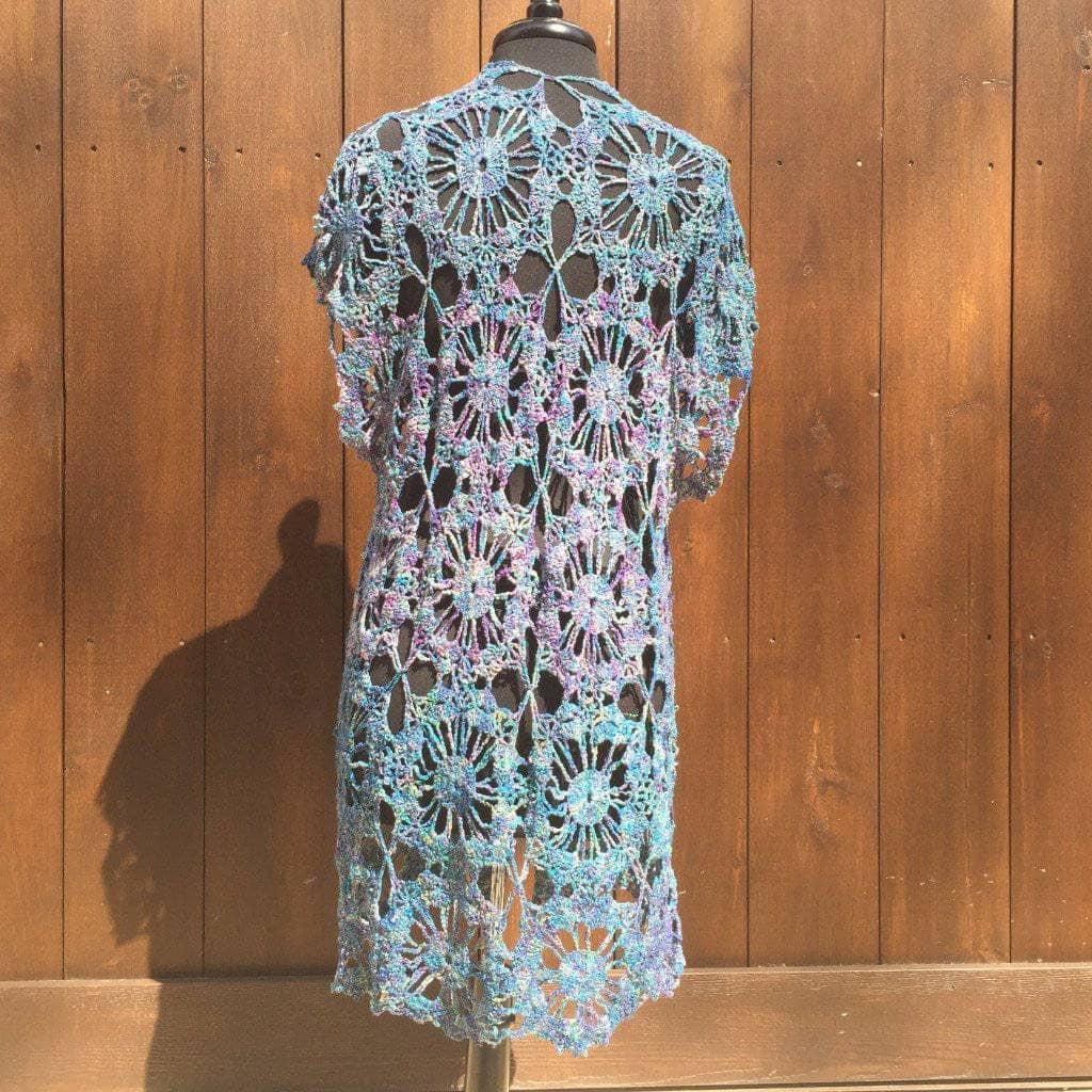 A handmade openwork duster worn as a light layering piece over a casual outfit
