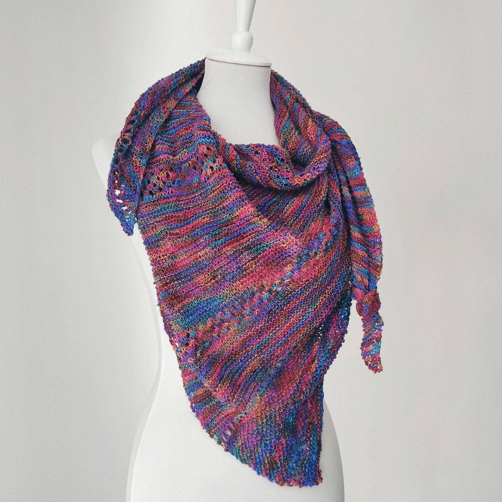 Close up of an openwork lattice knit shawl pattern showing delicate lace weight texture