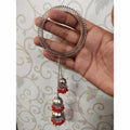 Wide silver-tone Indian bangle featuring red pearls and hanging chain embellishments