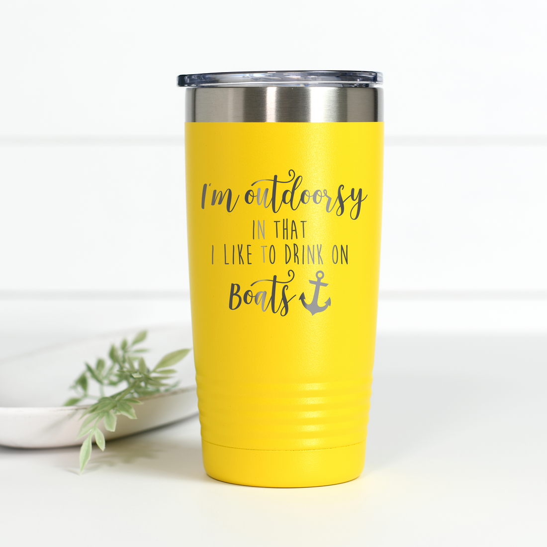 Bright yellow 20 oz stainless steel tumbler with the text I'm outdoorsy in that I like to drink on boats laser engraved on the front.