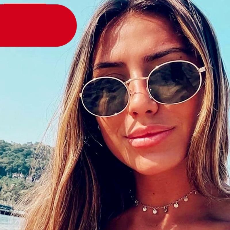 Close-up of trendy vintage oval sunglasses with a gold metal frame