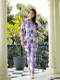 Woman wearing a vibrant abstract print muslin cotton co-ord set with collared shirt and straight trousers.