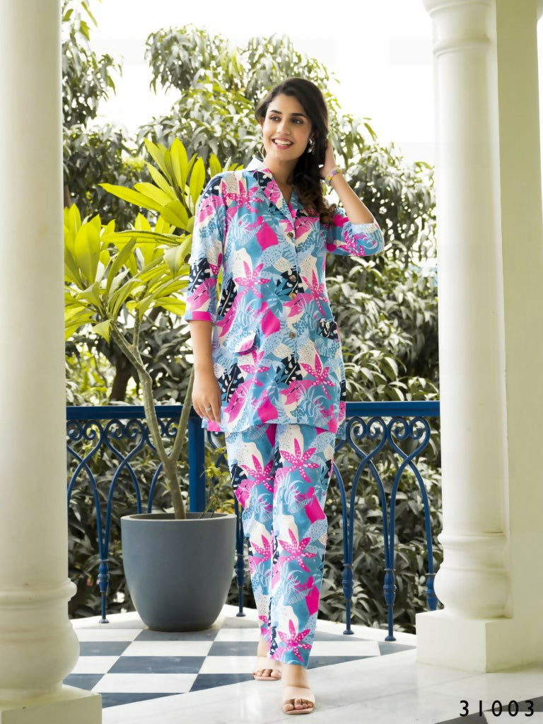 Woman wearing a vibrant abstract print muslin cotton co-ord set with collared shirt and straight trousers.