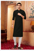 Toddler boy wearing a black art silk kurta with off-white pyjama bottoms