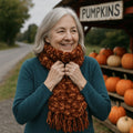 Close up of a chunky knit scarf in rust and golden-yellow harvest tones styled for autumn.