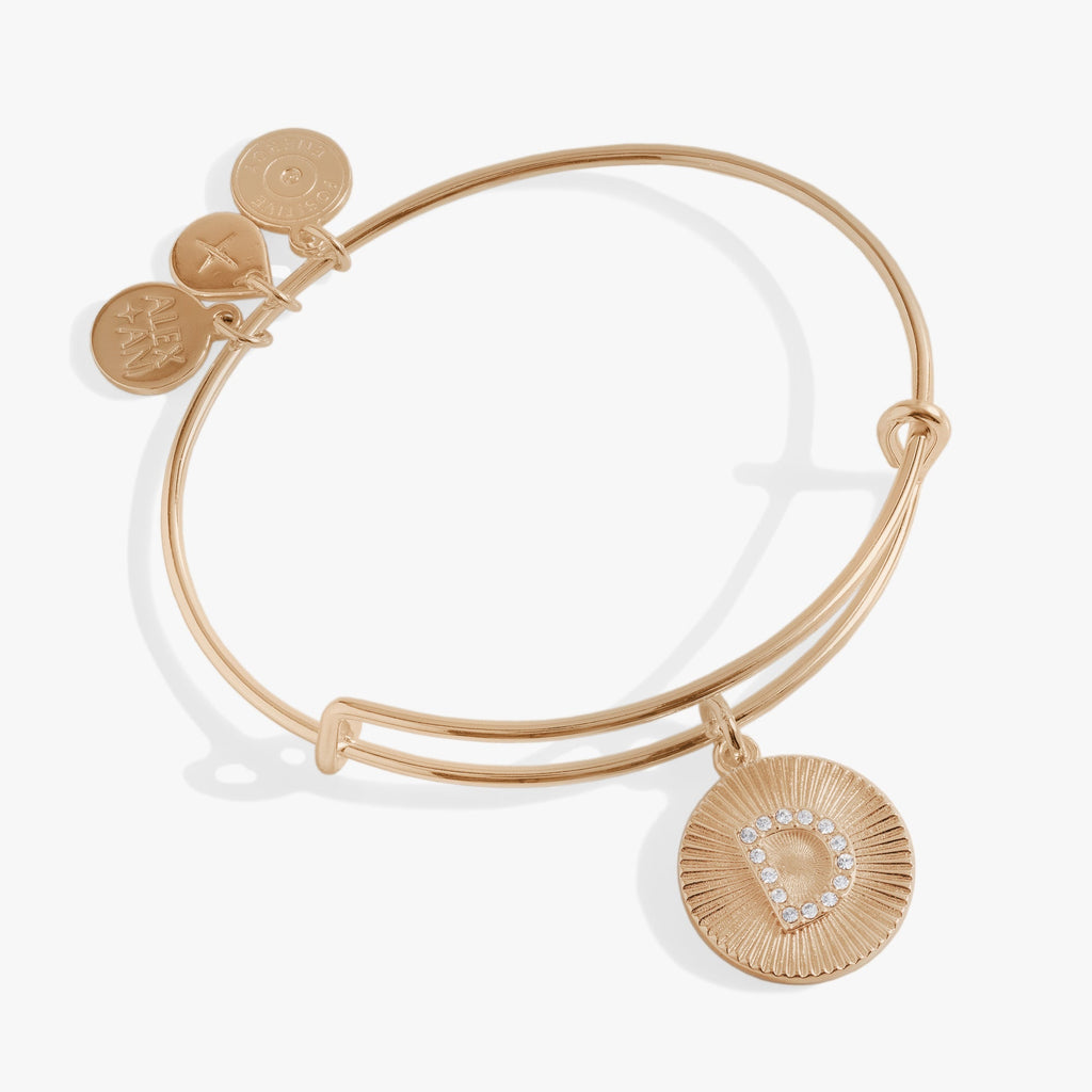 Pavé crystal initial D charm on a starburst textured bangle bracelet.