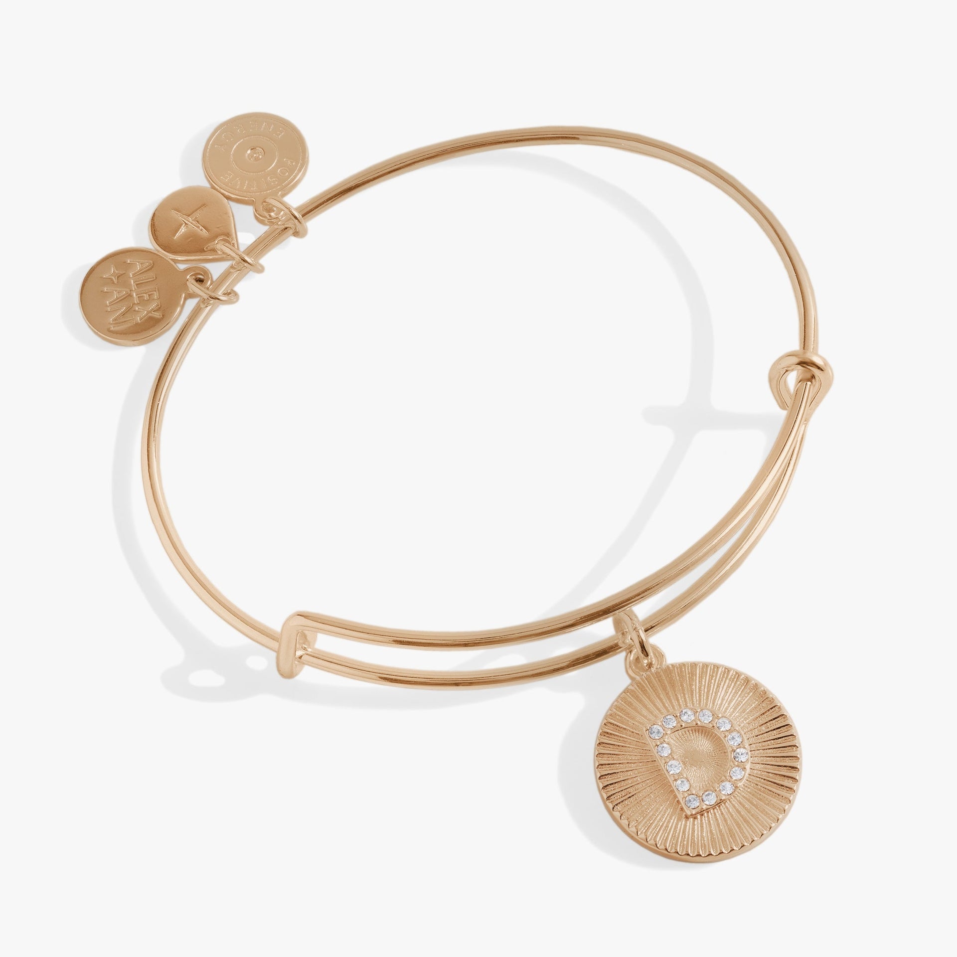 Pavé crystal initial D charm on a starburst textured bangle bracelet.