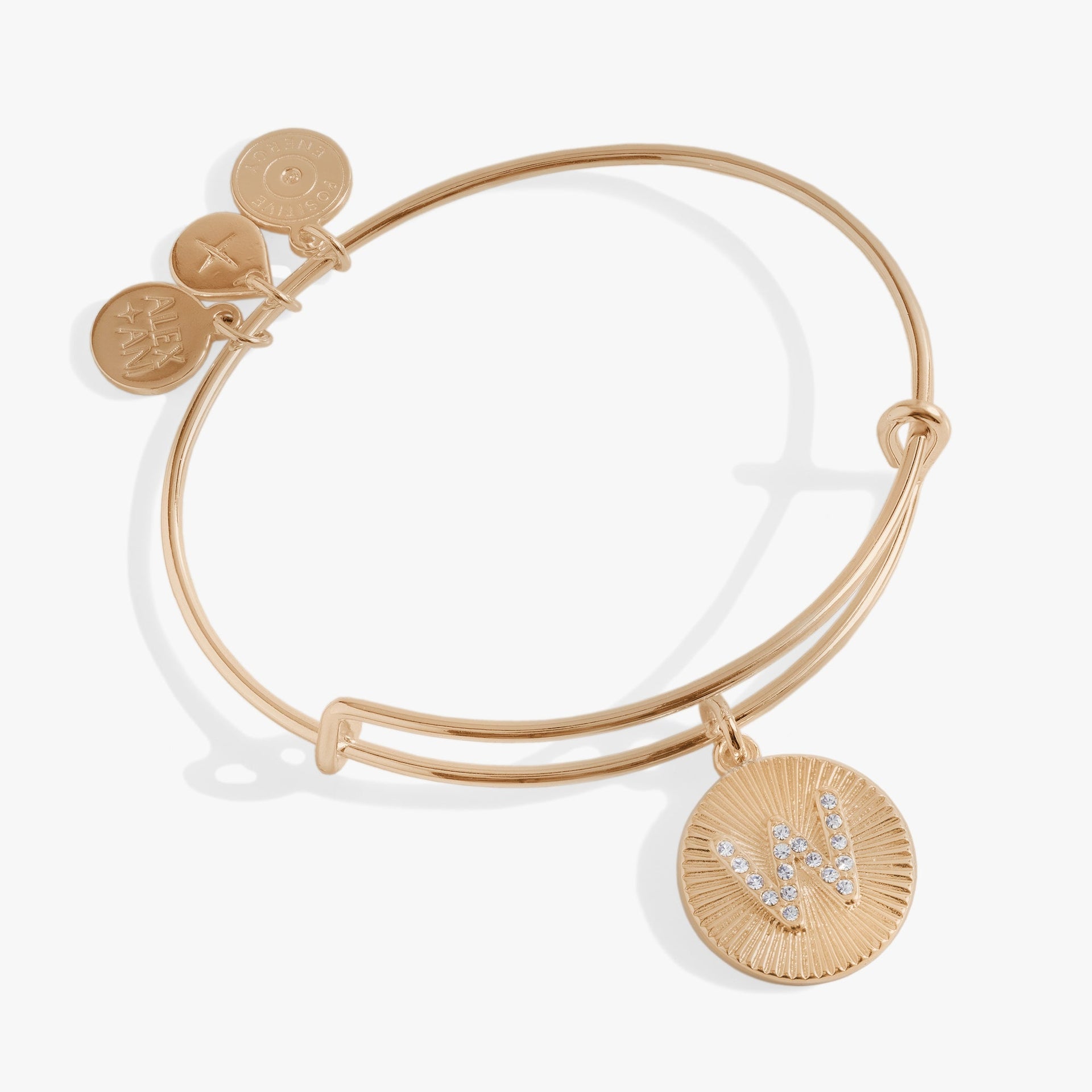 Gold-tone bangle bracelet featuring a starburst charm with a crystal-encrusted initial W.