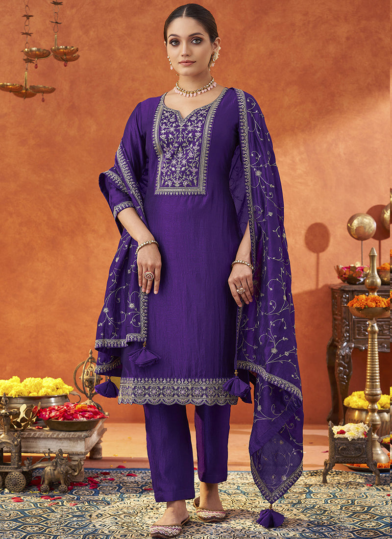Woman wearing a vibrant violet silk blend A-line salwar suit with intricate gold embroidery and three-quarter sleeves.