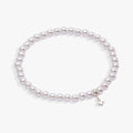 White pearl beaded stretch bracelet with a silver star charm on a neutral background.
