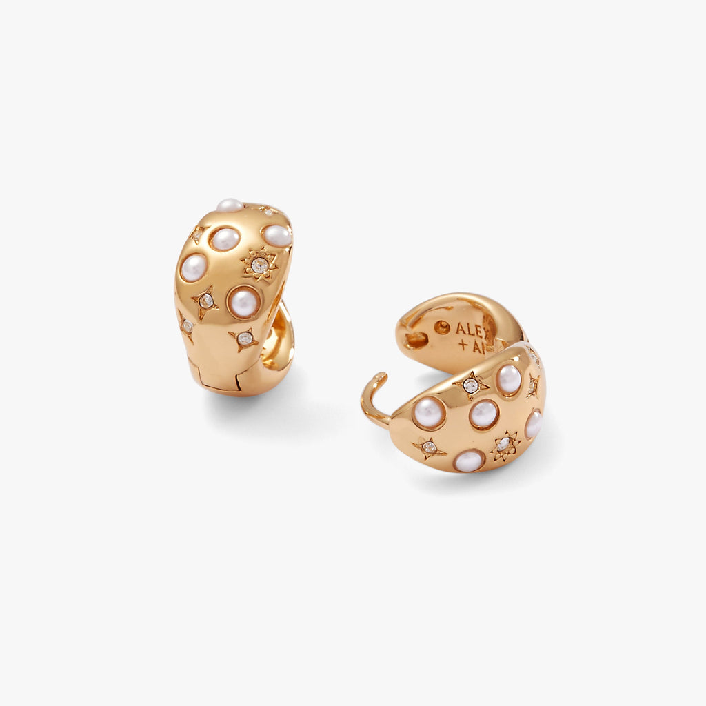 Gold huggie hoop earrings featuring a white pearl and pave crystals with a starburst pattern