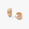 Gold huggie hoop earrings featuring a white pearl and pave crystals with a starburst pattern