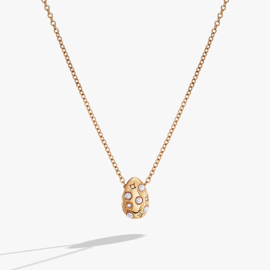 Pearl and crystal pendant necklace featuring an etched starburst design on an adjustable silver-tone chain.