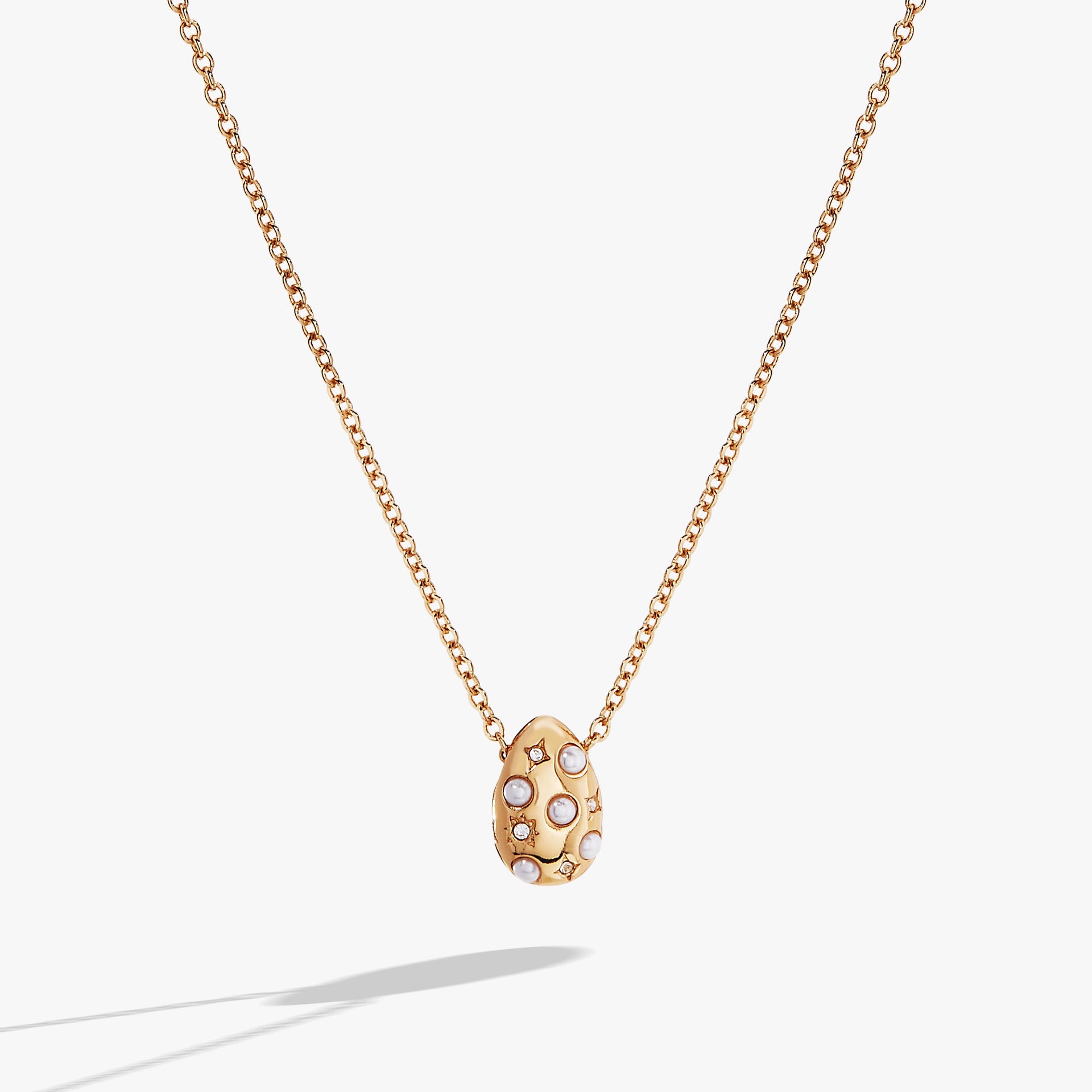 Pearl and crystal pendant necklace featuring an etched starburst design on an adjustable silver-tone chain.