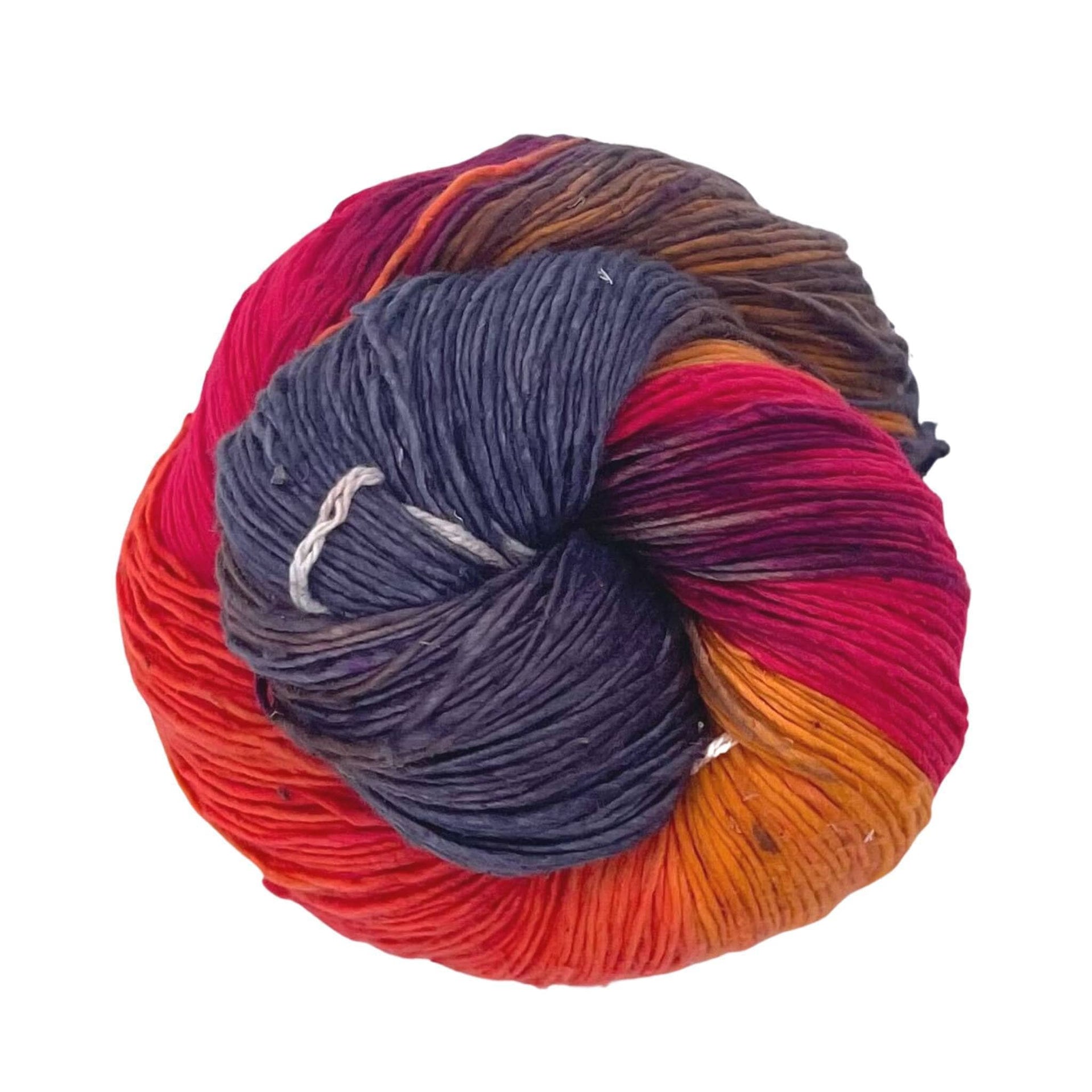 Close up of Peek-a-Boo lace weight recycled silk yarn in multicolor and dark-grey.