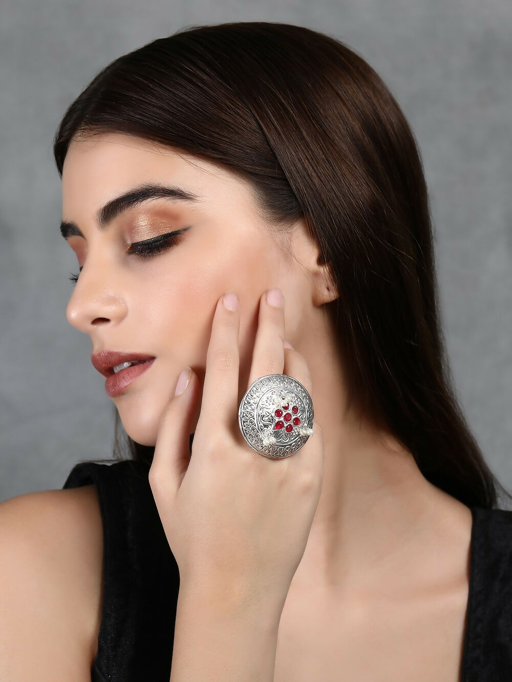 Handcrafted silver tone ring featuring a vibrant red stone and intricate metal pattern detailing.