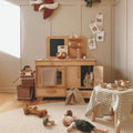 A small handcrafted natural wooden play kitchen with an oven and sink for toddlers