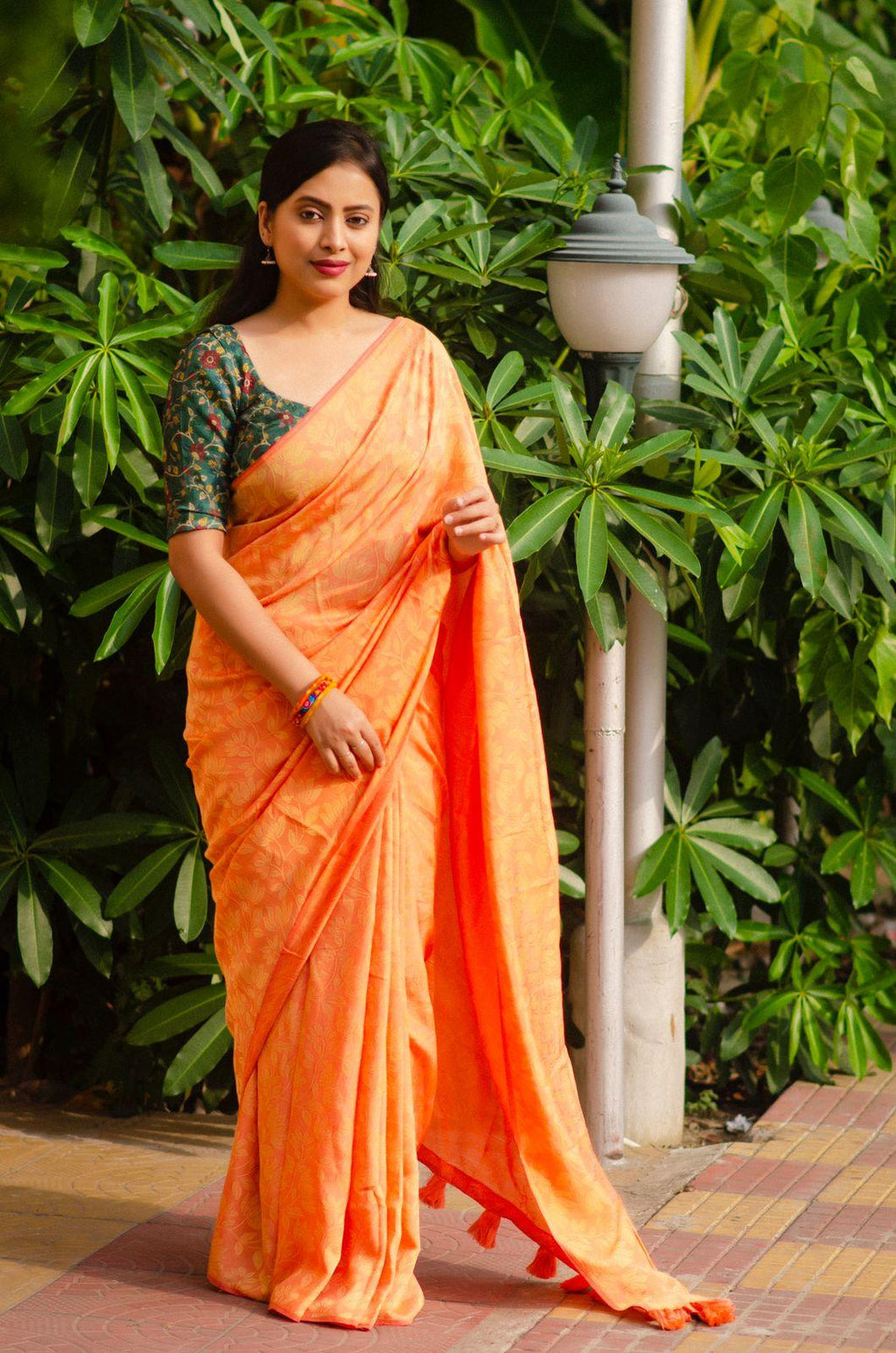 Saffron jute silk woven jacquard saree with dark green Kalamkari blouse and cotton tassels