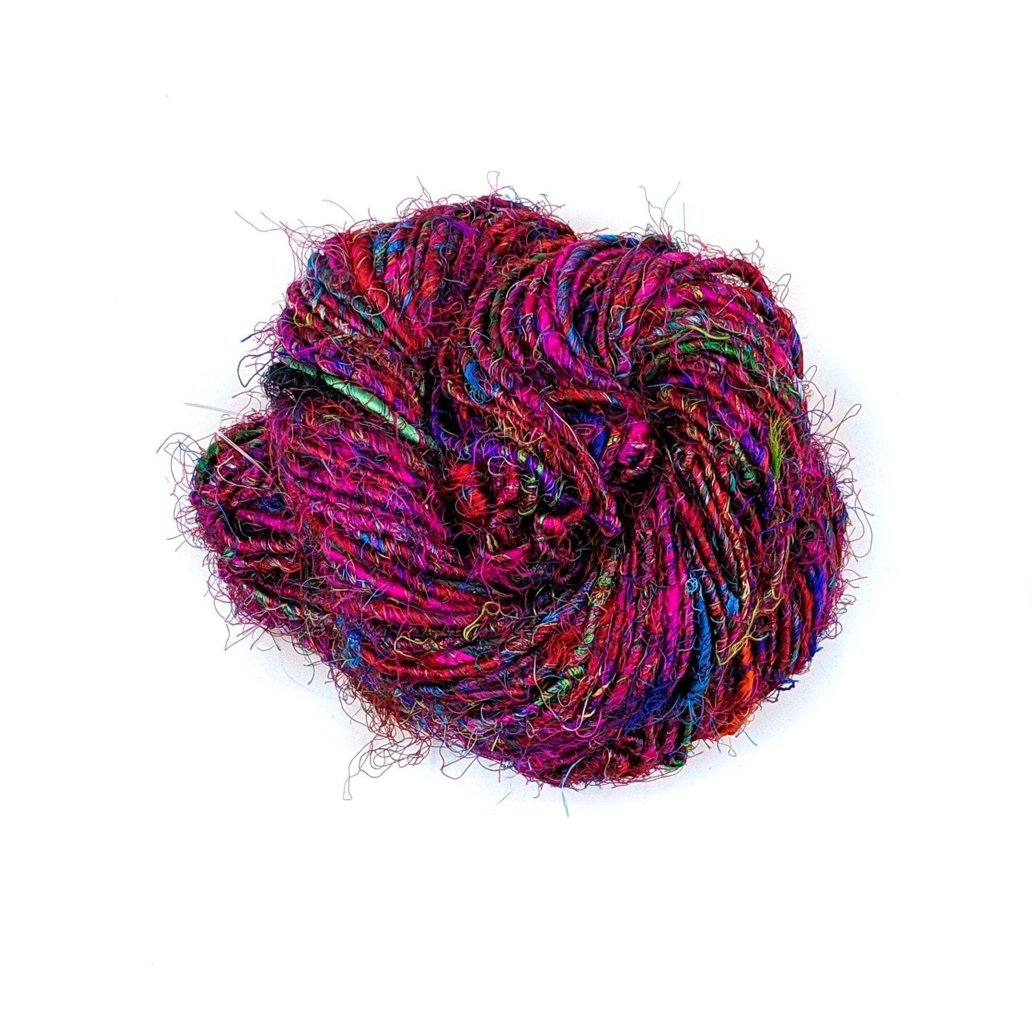 Close-up of vibrant multicolored handspun recycled sari silk yarn in magenta, blue, green, and orange.