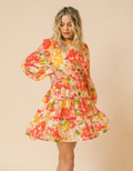 A woman wearing a printed woven mini dress with trendy cut-out detailing and a flattering silhouette.