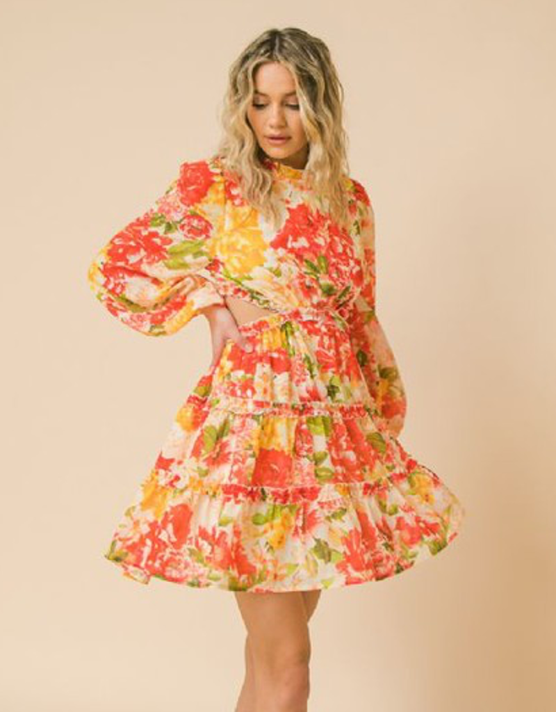 A woman wearing a printed woven mini dress with trendy cut-out detailing and a flattering silhouette.