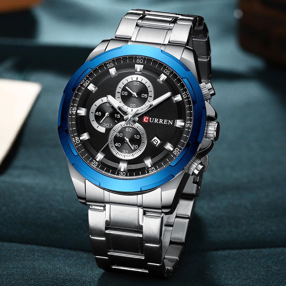 Close up of a men's sport watch with 3 sub-dials and a metal strap