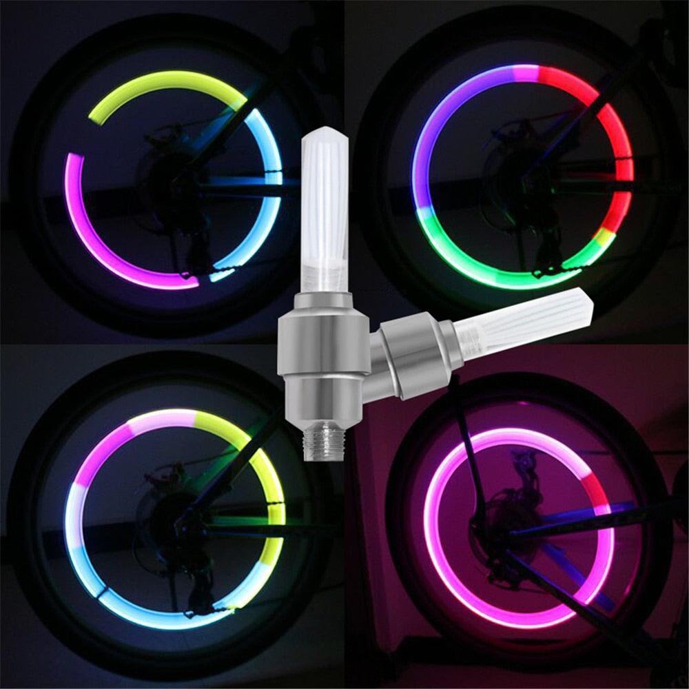Colorful LED neon light valve caps installed on a bicycle tire for night visibility.