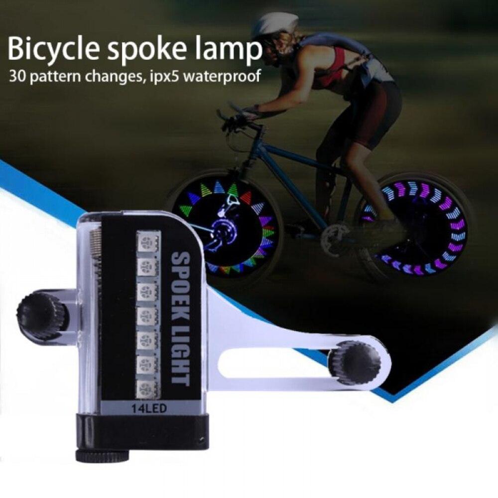 Mini LED bicycle wheel valve cap light emitting a bright glow on a bike tire