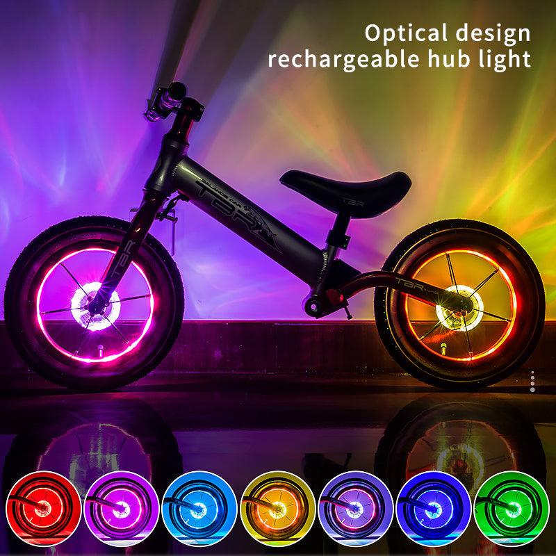 Colorful LED bicycle hub light illuminating a bike tire rim.
