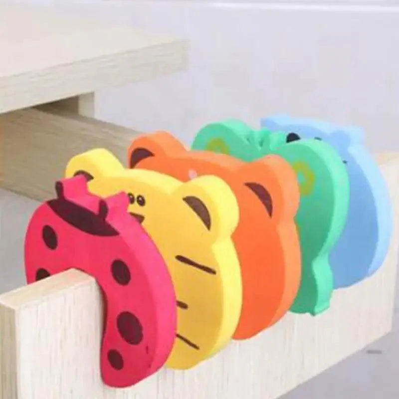 Colorful animal-themed foam door stopper used as a baby finger protector on a nursery door.