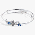 Alex And Ani Protection inline wire bangle featuring a hamsa hand, moon, lotus, and evil eye charms with clear crystals.